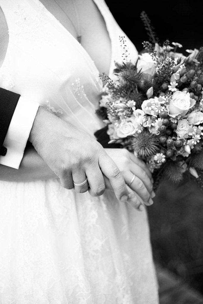 Umarmung Ehepaar und Hochzeitsblumen