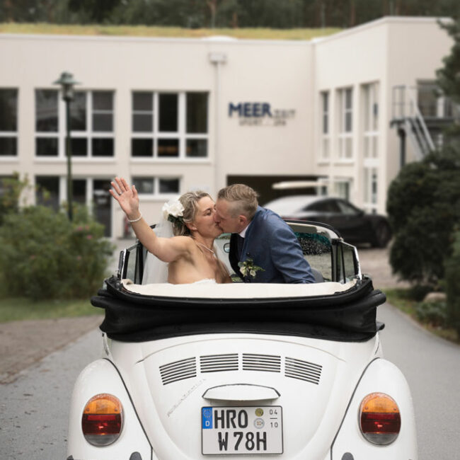Ehepaar küsst im Cabrio